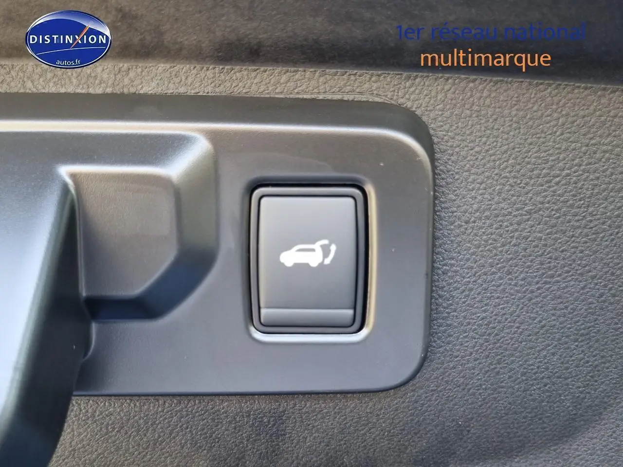 Bouton d'ouverture électrique du coffre sur panneau intérieur d'une Renault Rafale bleu sommet 2025.