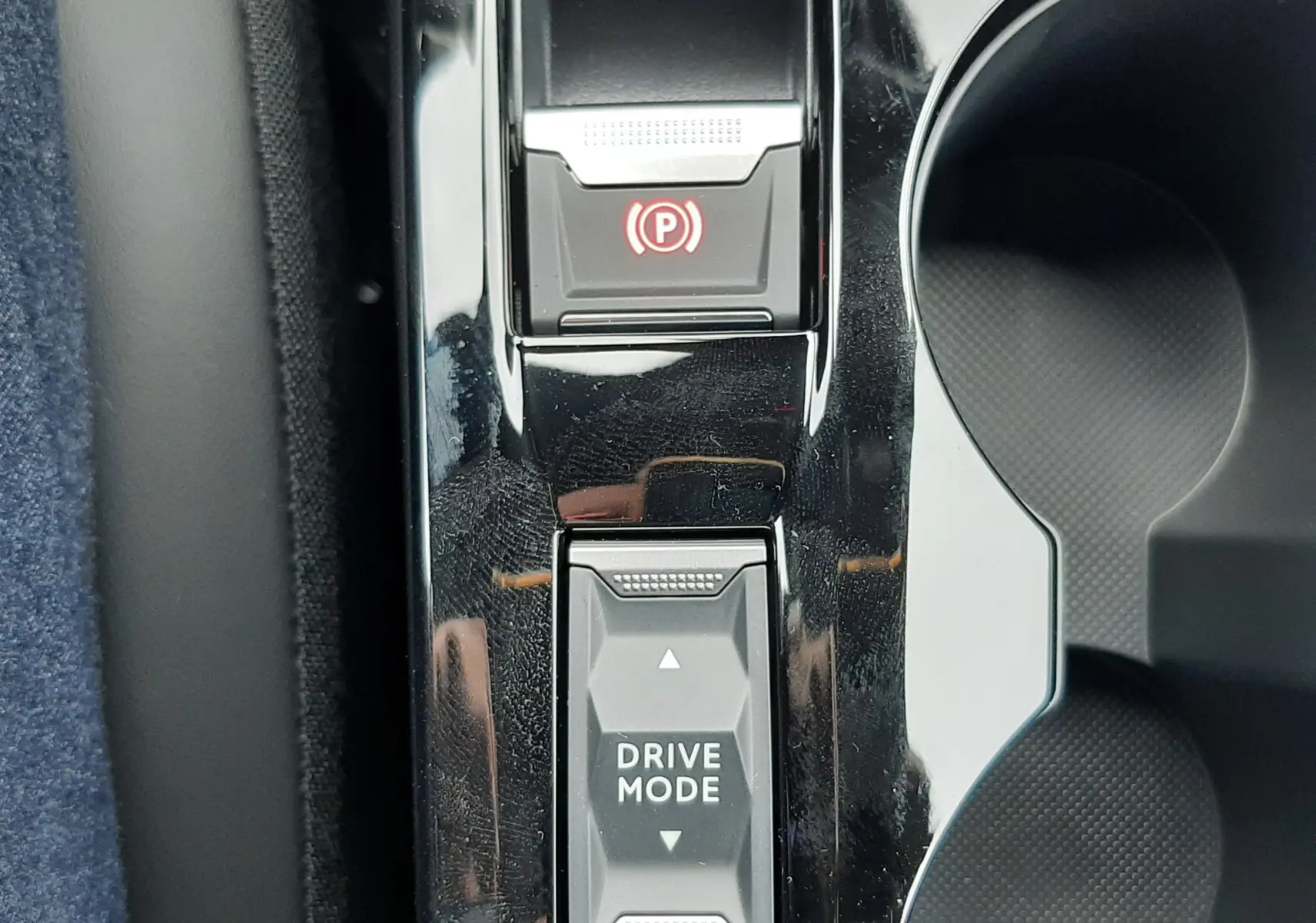 Vue rapprochée du levier de sélection Drive Mode et frein à main électronique sur la console centrale noire d'un Peugeot 2008 gris Artense.