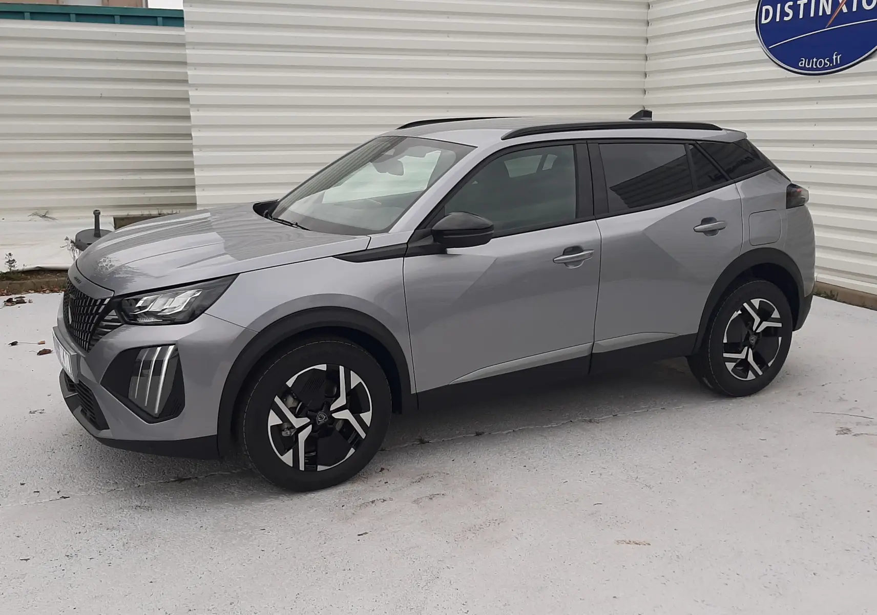 Peugeot 2008 hybride gris Artense vue 3/4 avant droit, avec jantes noires et toit panoramique noir.