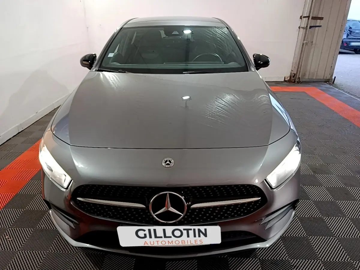 Vue avant d'une Mercedes Classe A 250 e AMG Line gris foncé avec phares LED allumés dans un garage.