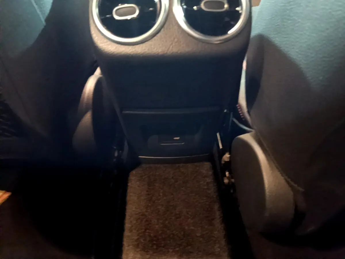 Vue rapprochée de la console arrière avec prises d’air rondes et port USB dans une Mercedes Classe A gris foncé.