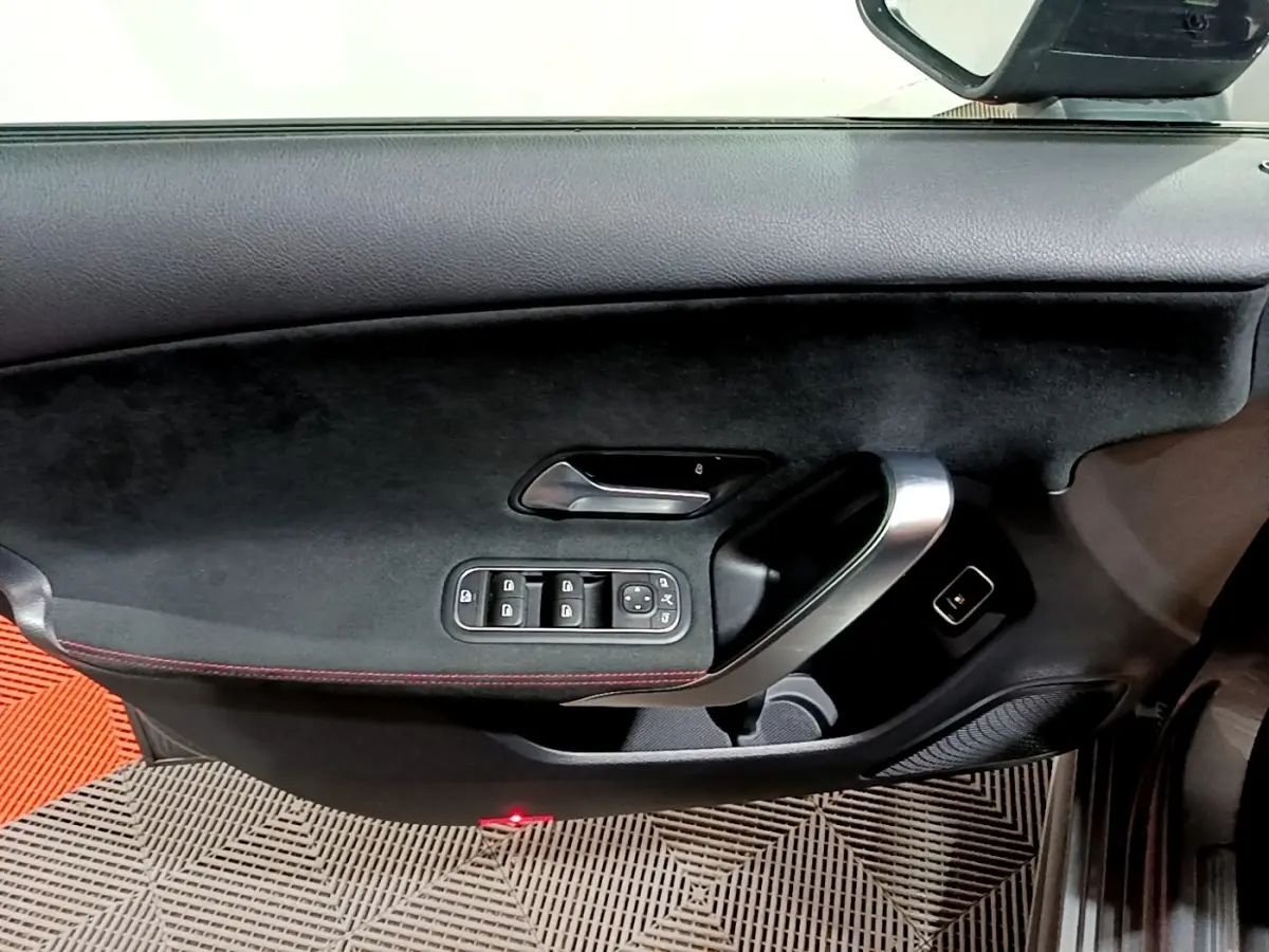 Vue intérieure côté gauche de la porte d’une Mercedes Classe A 250 e AMG Line 2021 avec garniture noire et poignée alu.