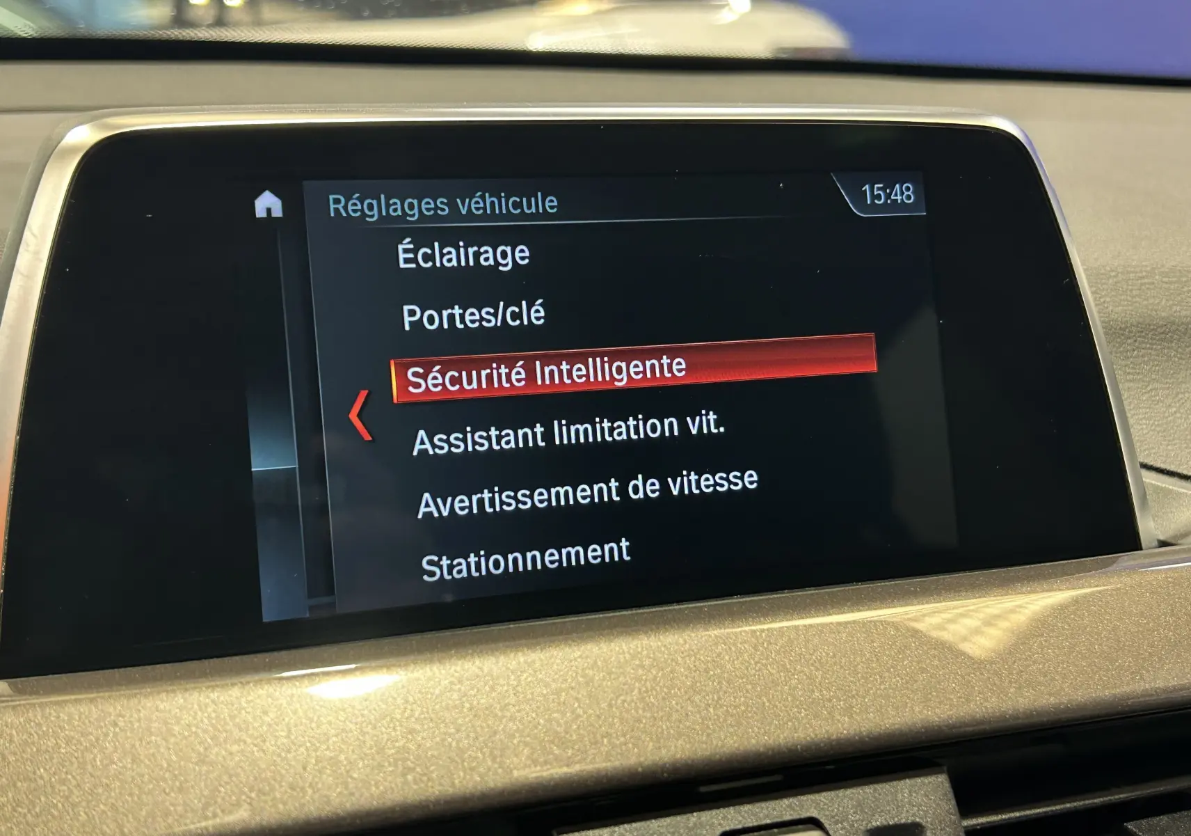 Écran central du tableau de bord de BMW X1 blanc 2018 affichant les réglages de sécurité intelligente.