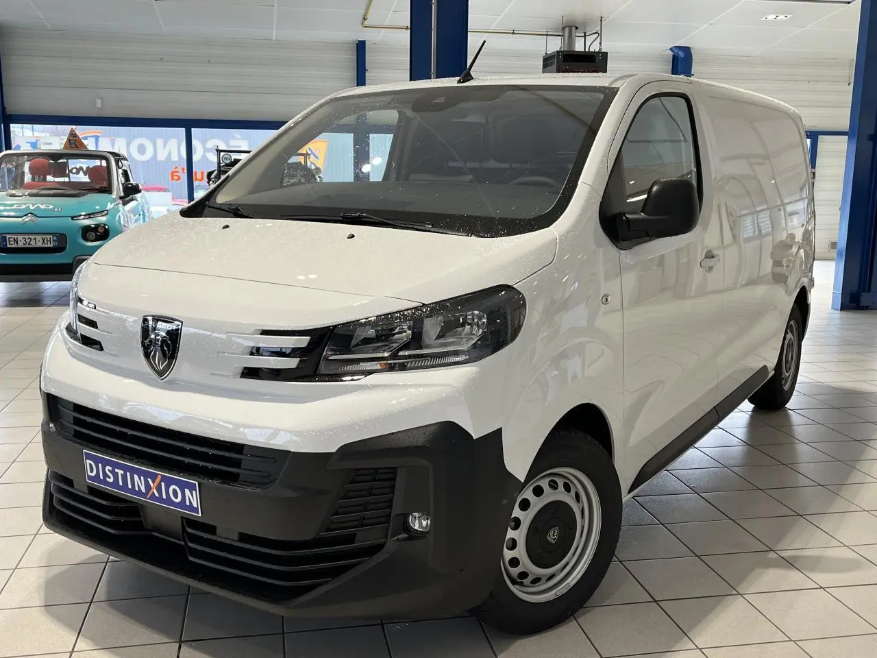 Vue 3/4 avant droit d'un Peugeot Expert Fourgon blanc 2024 en showroom avec calandre noire et jantes acier.