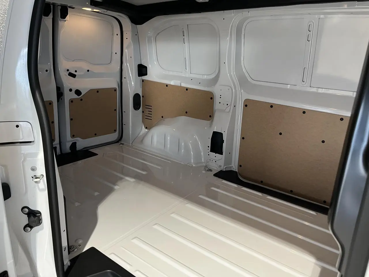 Intérieur de la zone de chargement du Peugeot Expert Fourgon blanc 2024, vue côté gauche avec panneaux de protection en bois.