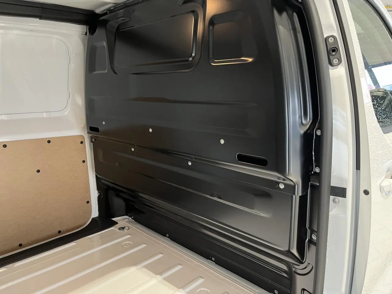 Intérieur de l'espace de chargement du Peugeot Expert Fourgon blanc 2024, vue côté droit avec cloison noire et parois blanches.