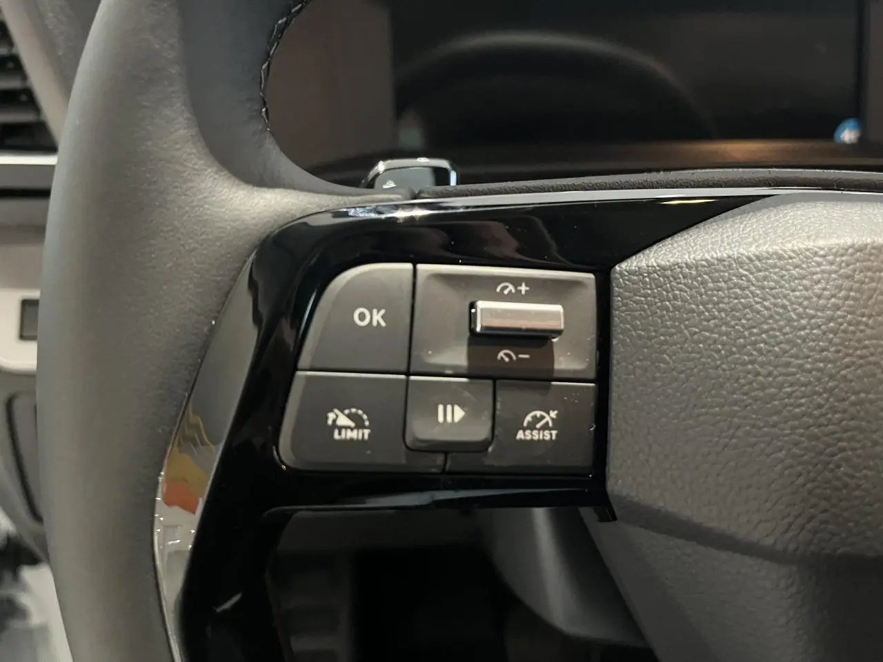 Gros plan sur les commandes de régulateur de vitesse au volant cuir noir du Peugeot Expert Fourgon blanc 2024.