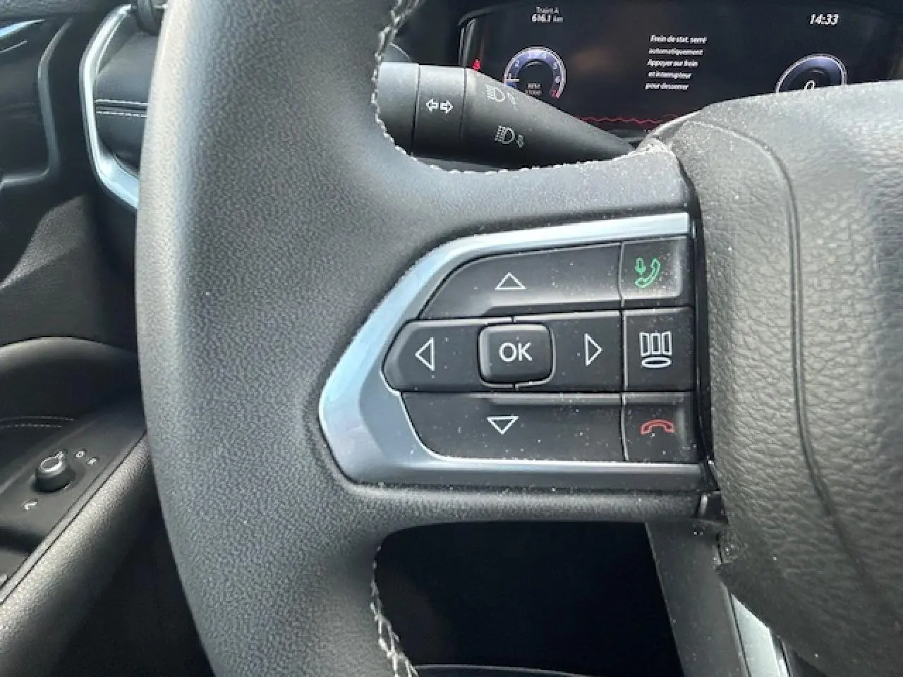 Gros plan sur les commandes multifonctions à gauche du volant du Jeep Compass 2022, intérieur noir.
