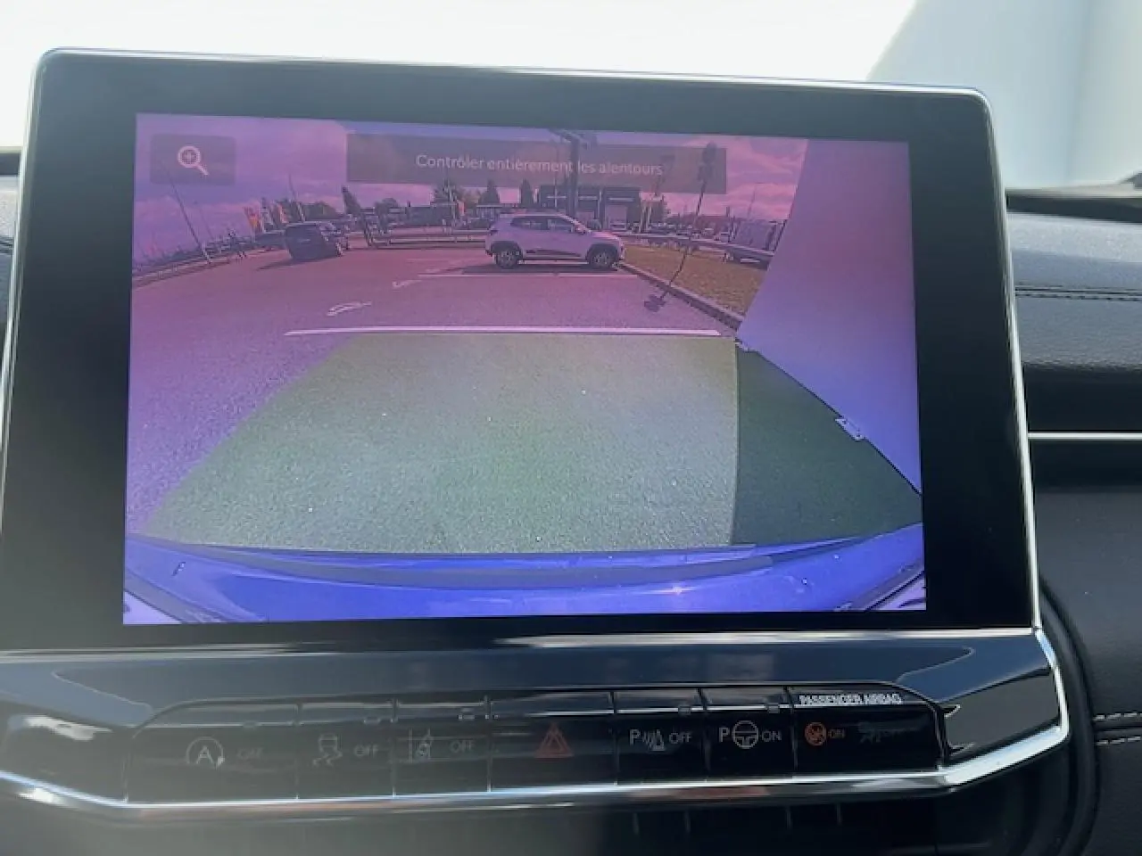 Affichage caméra de recul du Jeep Compass 2022 en peinture métallisée Blue Shade, vue arrière avec parking visible.