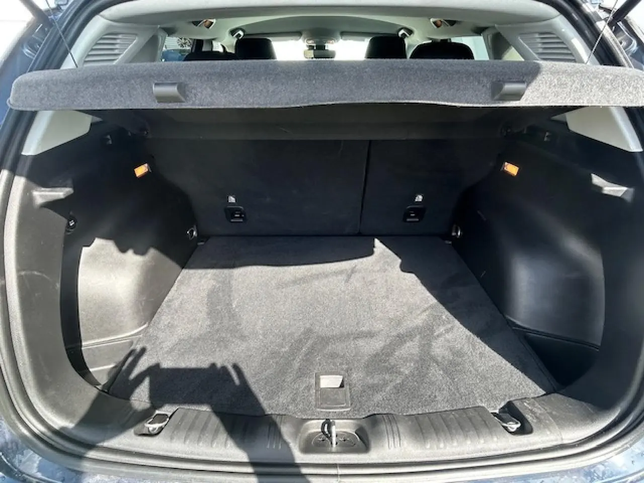 Coffre ouvert du Jeep Compass 2022 Blue Shade, montrant un espace de chargement propre et tapis noir.