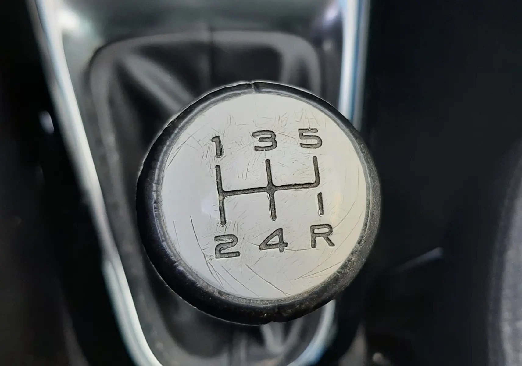 Gros plan sur le pommeau de la boîte manuelle gris et noir d'une Citroën C3 noire de 2016.