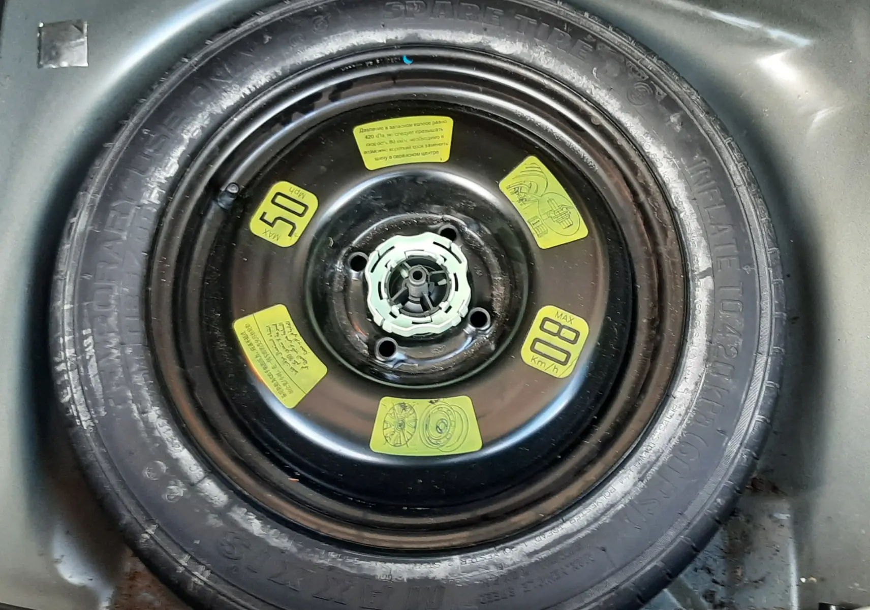 Gros plan sur la roue de secours noire du coffre d'une Citroën C3 BlueHDi 75 Exclusive noire de 2016.