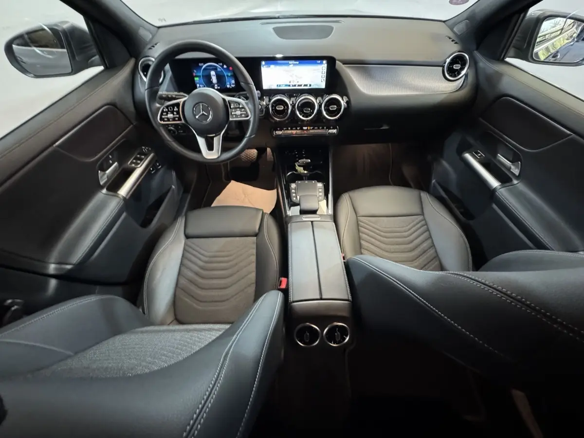 Vue intérieure avant du Mercedes GLA 250 e Business Line 2023, sièges cuir noirs et tableau de bord avec écran tactile.