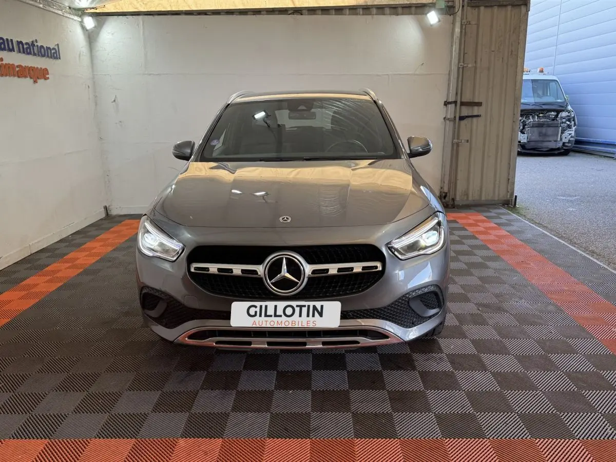 Vue avant d'une Mercedes GLA 250 e Business Line gris foncé avec calandre et phares LED allumés, dans un garage.