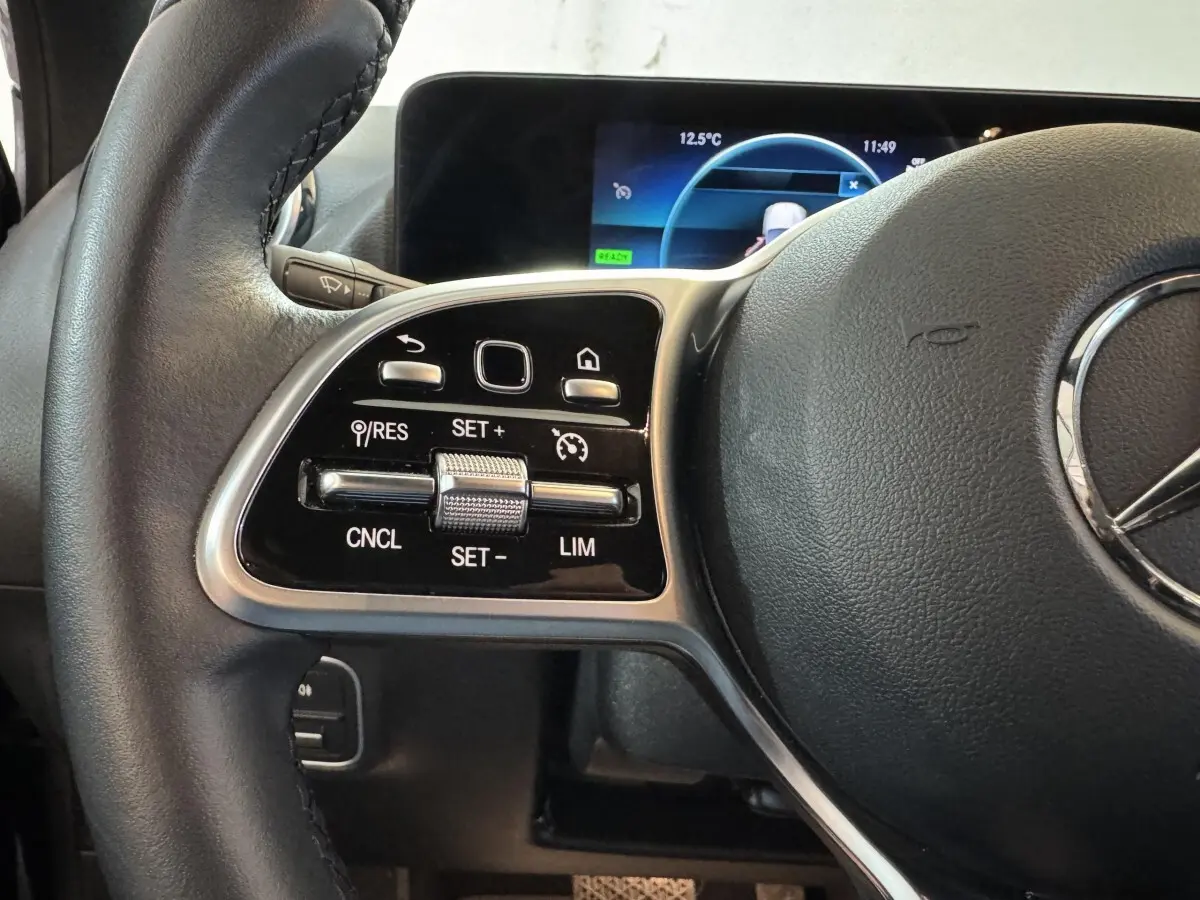 Gros plan sur le volant cuir multifonctions côté gauche du Mercedes GLA 250 e Business Line 2023 avec commandes tactiles.