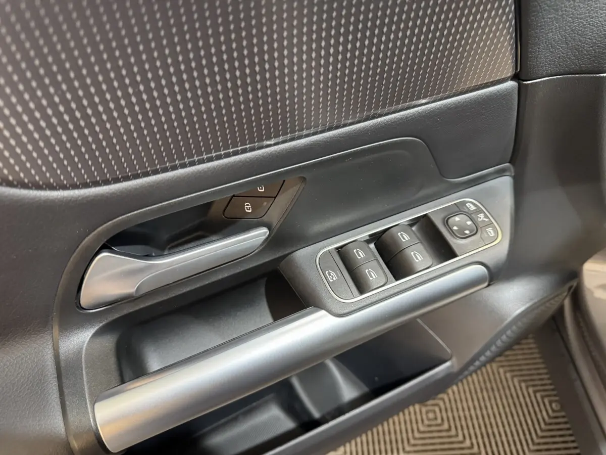Détail de la porte côté conducteur du Mercedes GLA 250 e Business Line 2023, avec commandes de vitres et poignée argentée.