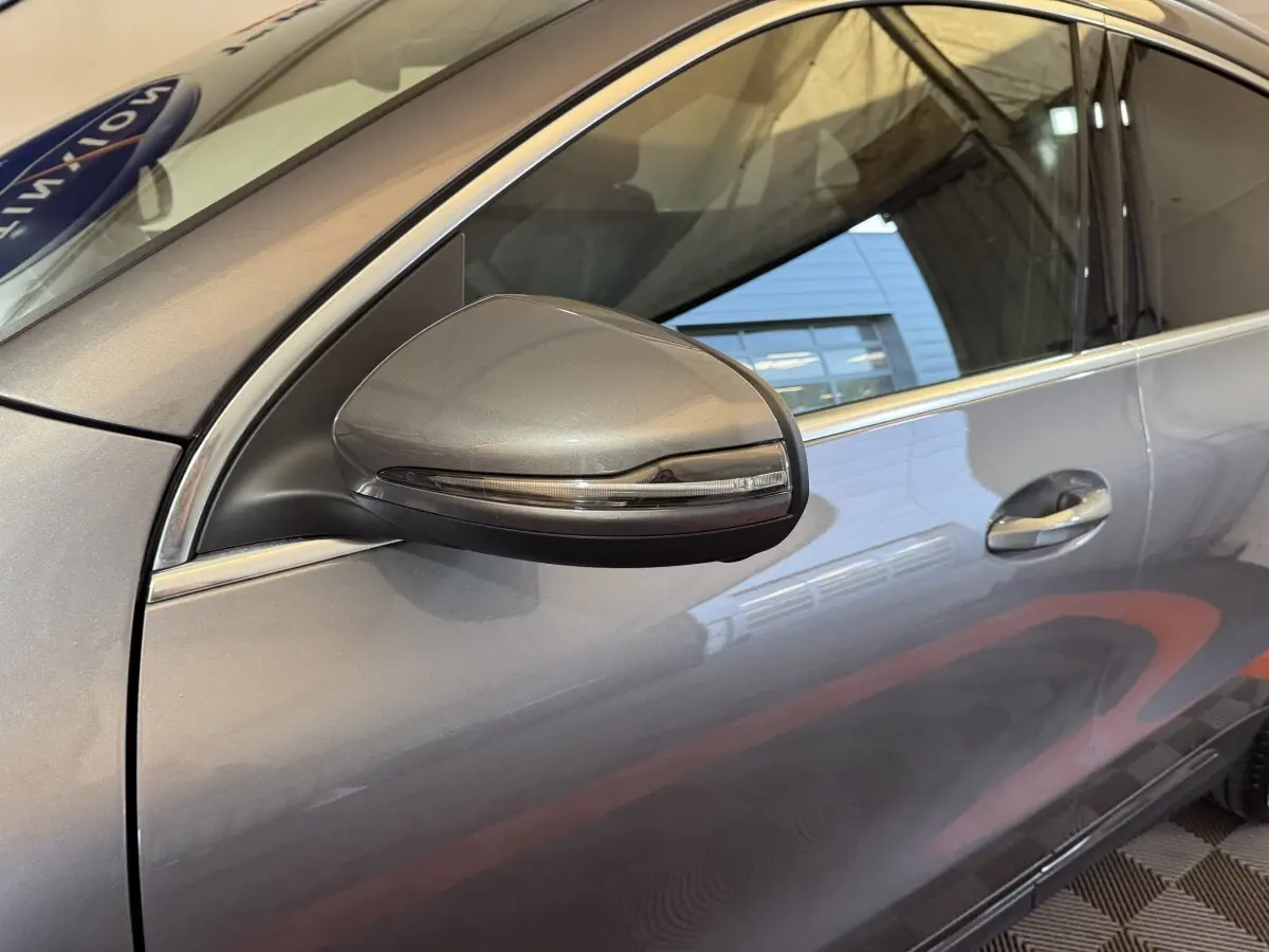 Gros plan sur le rétroviseur côté gauche gris foncé d’un Mercedes GLA 250 e Business Line 2023 avec porte et poignée visibles.