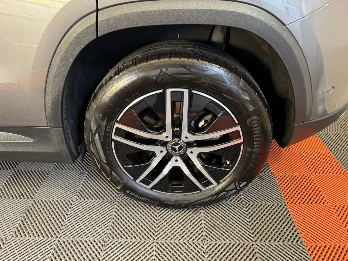 Gros plan sur la roue avant droite d’un Mercedes GLA 250 e Business Line gris foncé avec jante alliage noire et argent.