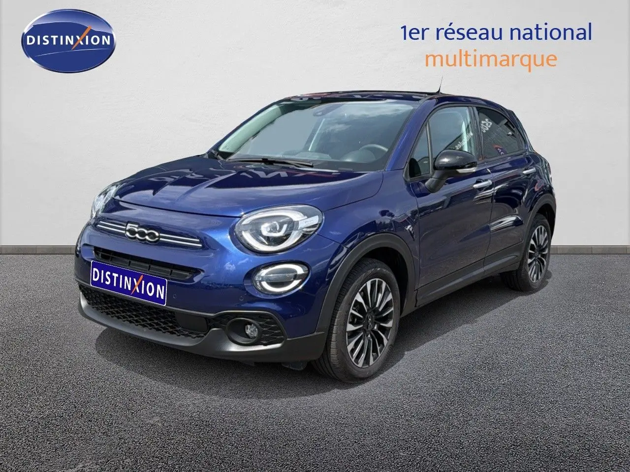 Fiat 500X bleu Venezia en 3/4 avant droit, mettant en valeur ses jantes alliage et ses optiques LED rondes.