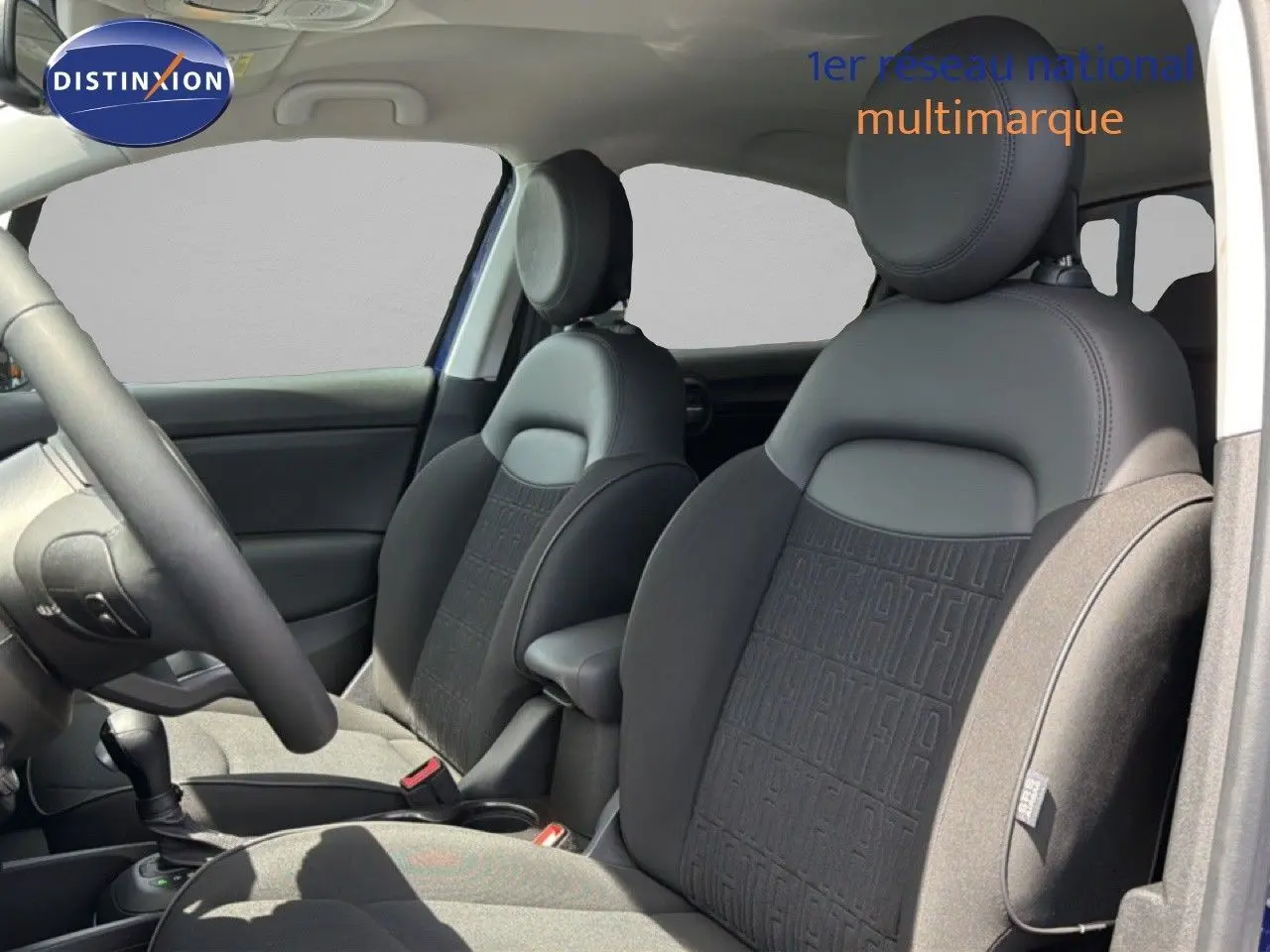 Intérieur de la FIAT 500X 2024, vue côté gauche sur les sièges avant en tissu et cuir noir avec motifs FIAT.