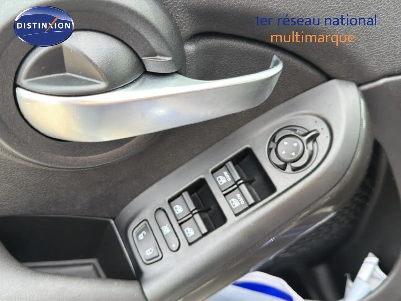 Détail de la porte côté conducteur de la FIAT 500X 2024, montrant les commandes des vitres et le verrouillage en plastique noir.