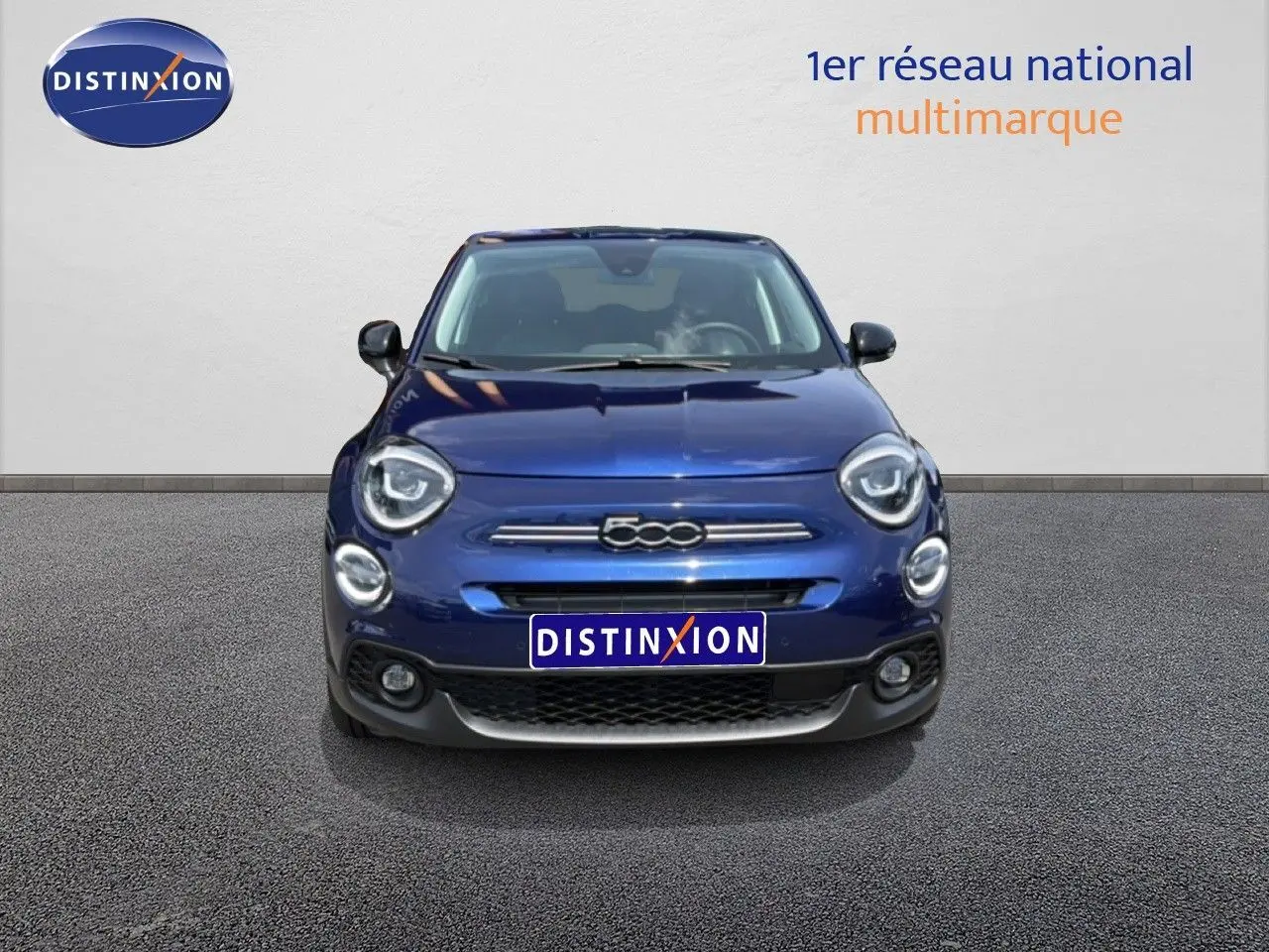 Vue avant d'une Fiat 500X 2024 en bleu Venezia, avec logo distinctif et phares ronds LED visibles.