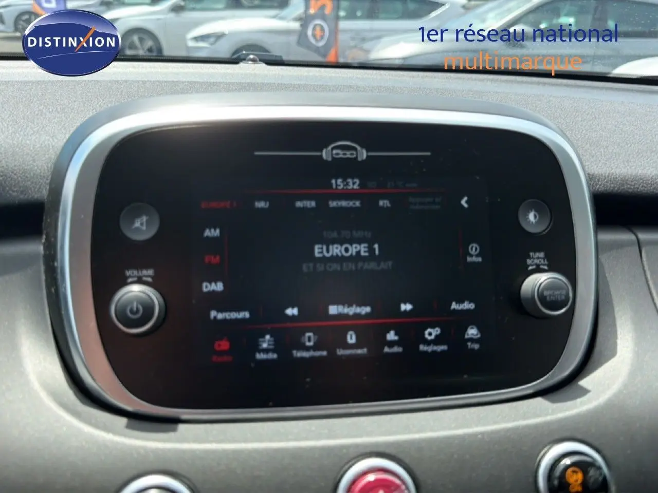 Écran tactile central de la Fiat 500X 2024, affichant la radio Europe 1, entouré de commandes circulaires.