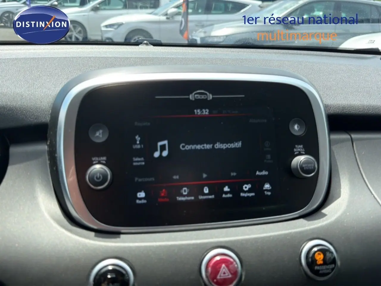 Écran tactile central du tableau de bord de la FIAT 500X 2024 avec commandes audio et climatisation visibles.