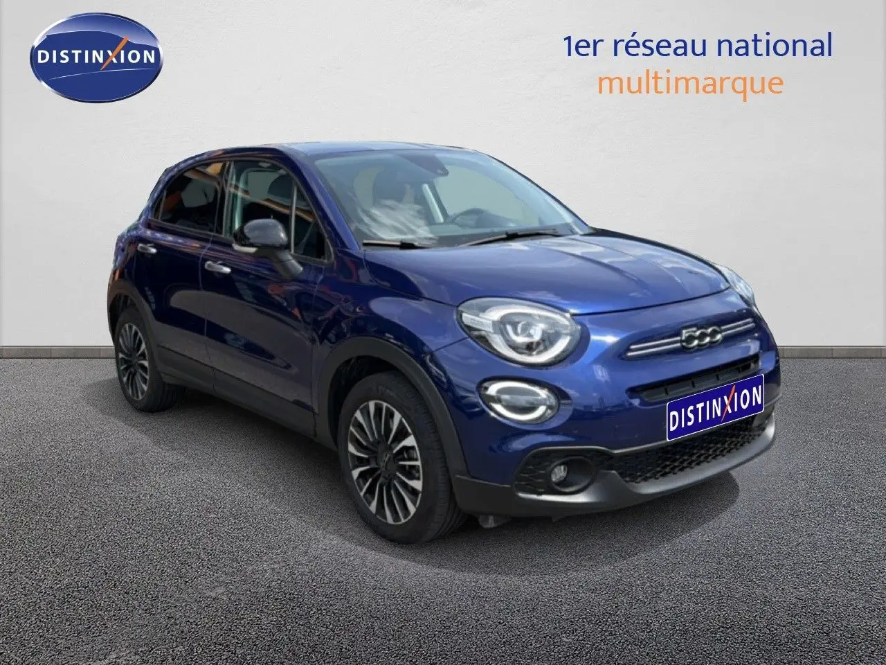 Vue 3/4 avant gauche d'une Fiat 500X 2024 bleu Venezia avec jantes alliage et calandre distinctive.