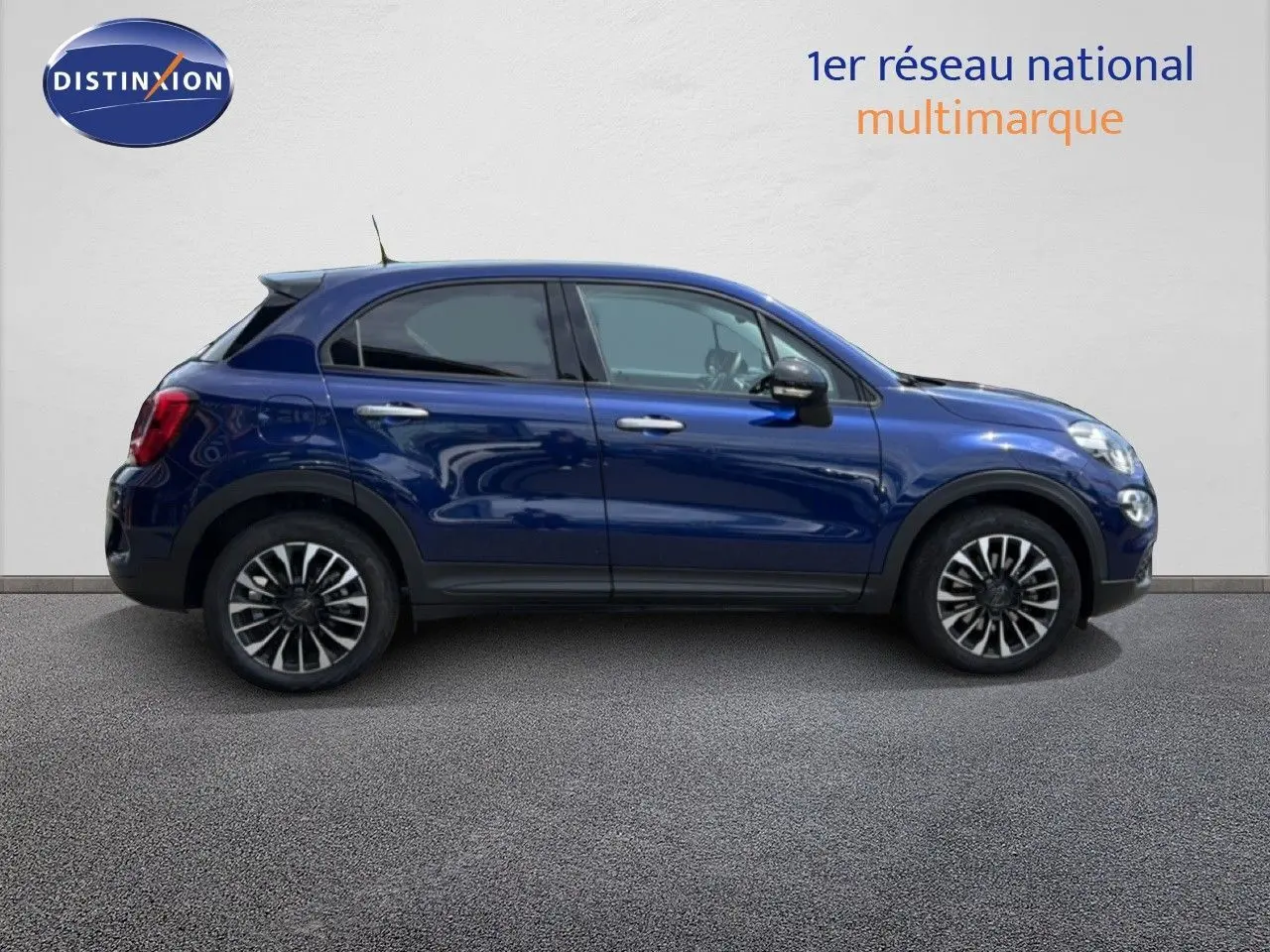 Profil latéral droit d'un FIAT 500X bleu Venezia 2024 avec jantes alliage et détails noirs contrastants.