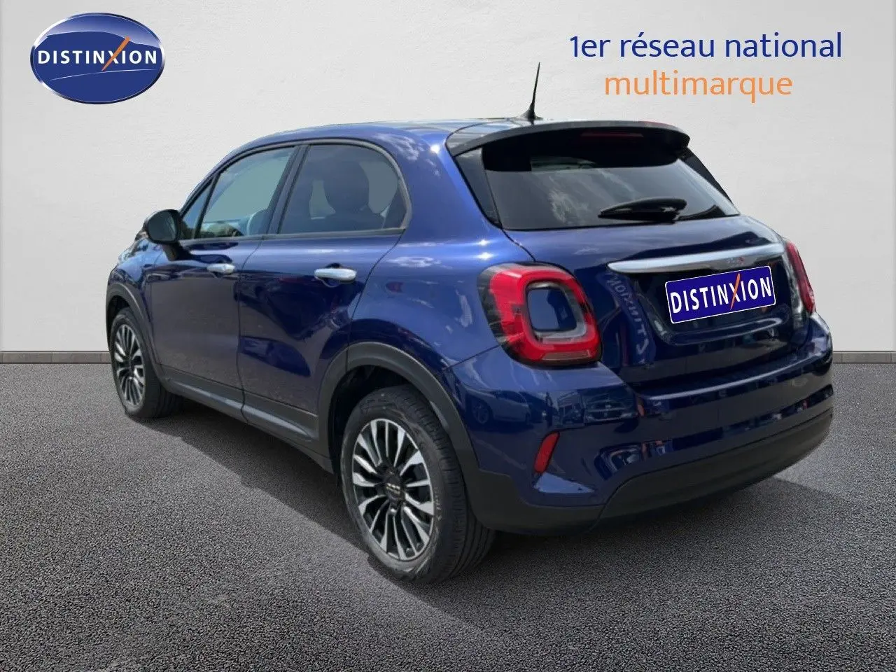Vue 3/4 arrière droite d'une FIAT 500X 2024 bleu Venezia avec jantes alliage et feux arrière LED distinctifs.