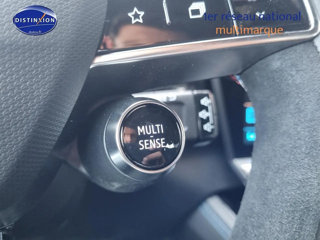 Gros plan sur le bouton Multi-Sense du tableau de bord d'une Renault Rafale noire étoile, intérieur moderne et soigné.