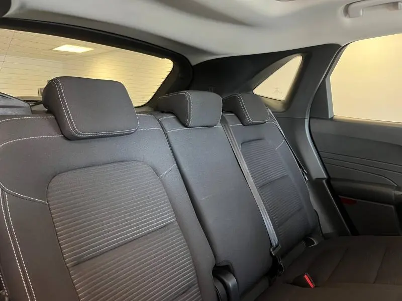 Vue intérieure arrière droite des sièges noirs avec surpiqûres blanches du Ford Kuga 2022 Titanium hybride.