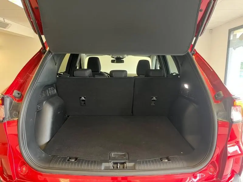 Coffre ouvert vu de l'arrière du Ford Kuga rouge Premium Lucid avec banquette arrière noire et intérieur spacieux.