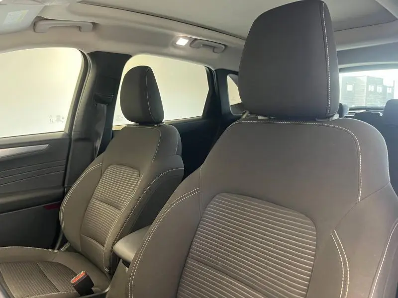 Gros plan sur les sièges avant noirs avec surpiqûres blanches du Ford Kuga 2022, vue côté droit intérieur.