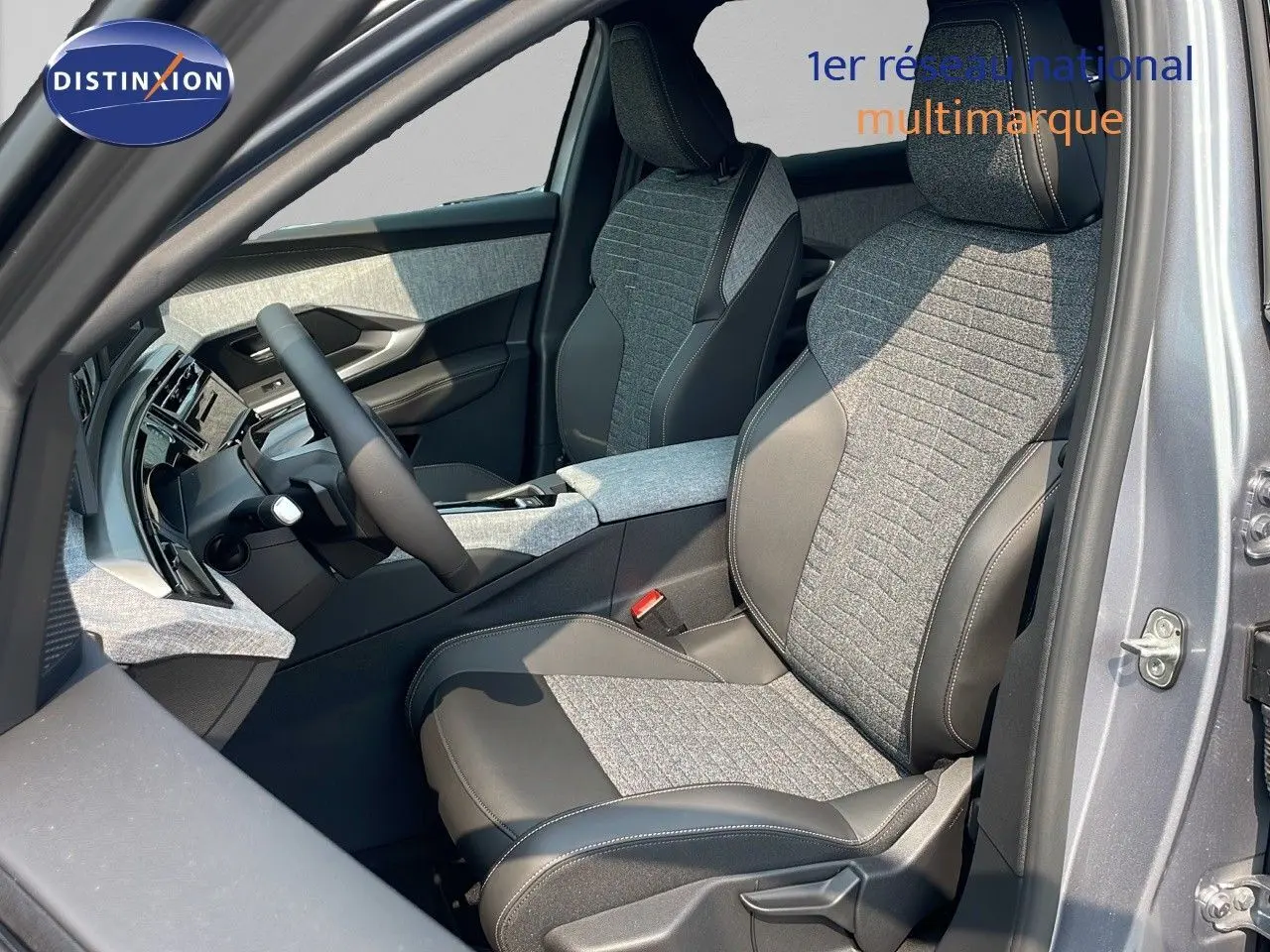 Vue intérieure côté conducteur du Peugeot 3008 Hybrid gris Artense, sièges tissu et cuir noir avec surpiqûres contrastées.