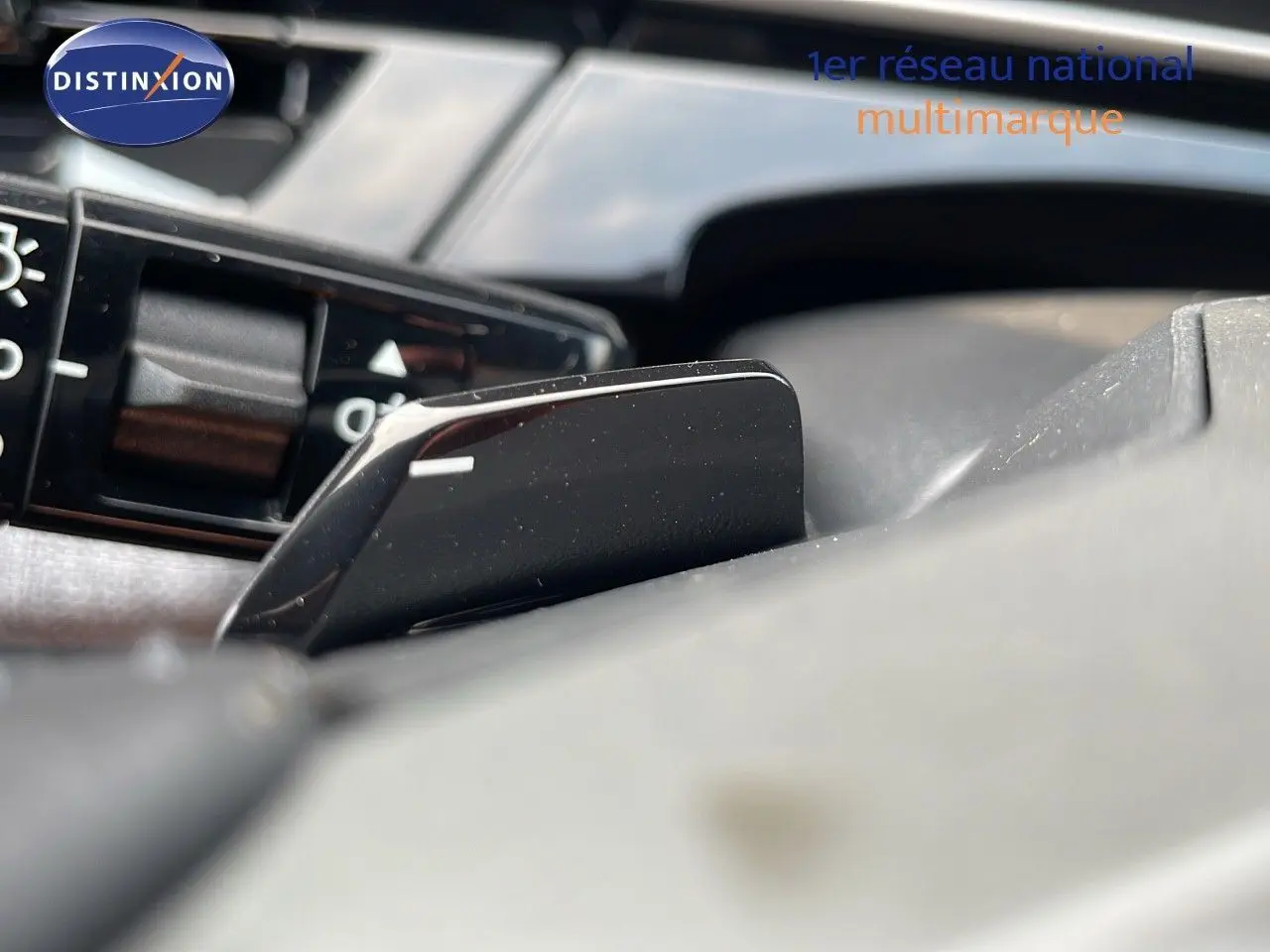 Gros plan sur la palette de changement de vitesse noire du tableau de bord d’un Peugeot 3008 Hybrid gris 2025.