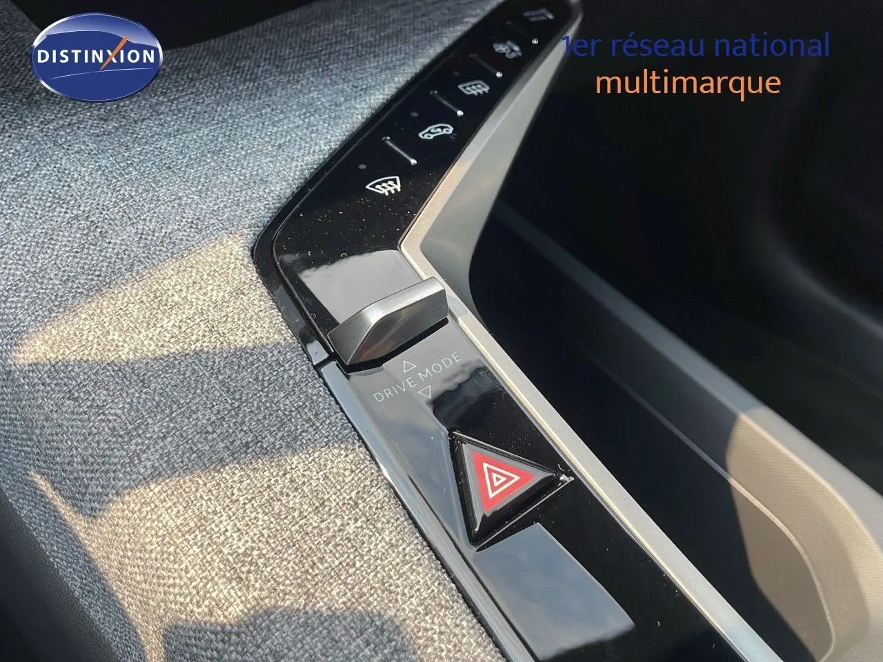 Détail de la console centrale du Peugeot 3008 Hybrid 2025 montrant le bouton de mode de conduite et le triangle de signalisation d'urgence.