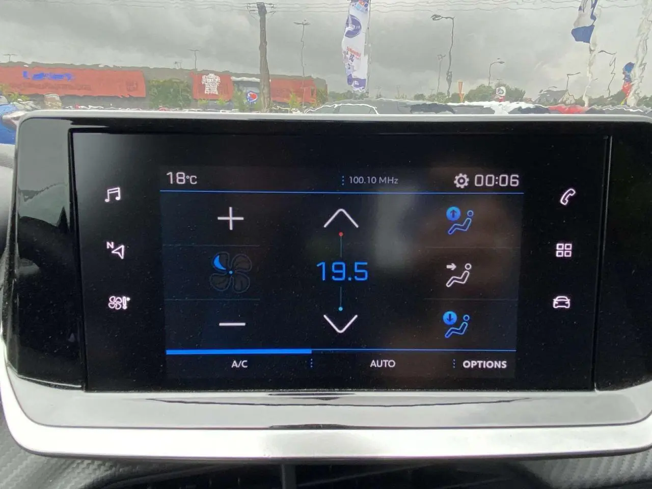 Écran tactile central de la Peugeot 208 2023 affichant la climatisation automatique à 19,5°C en intérieur.