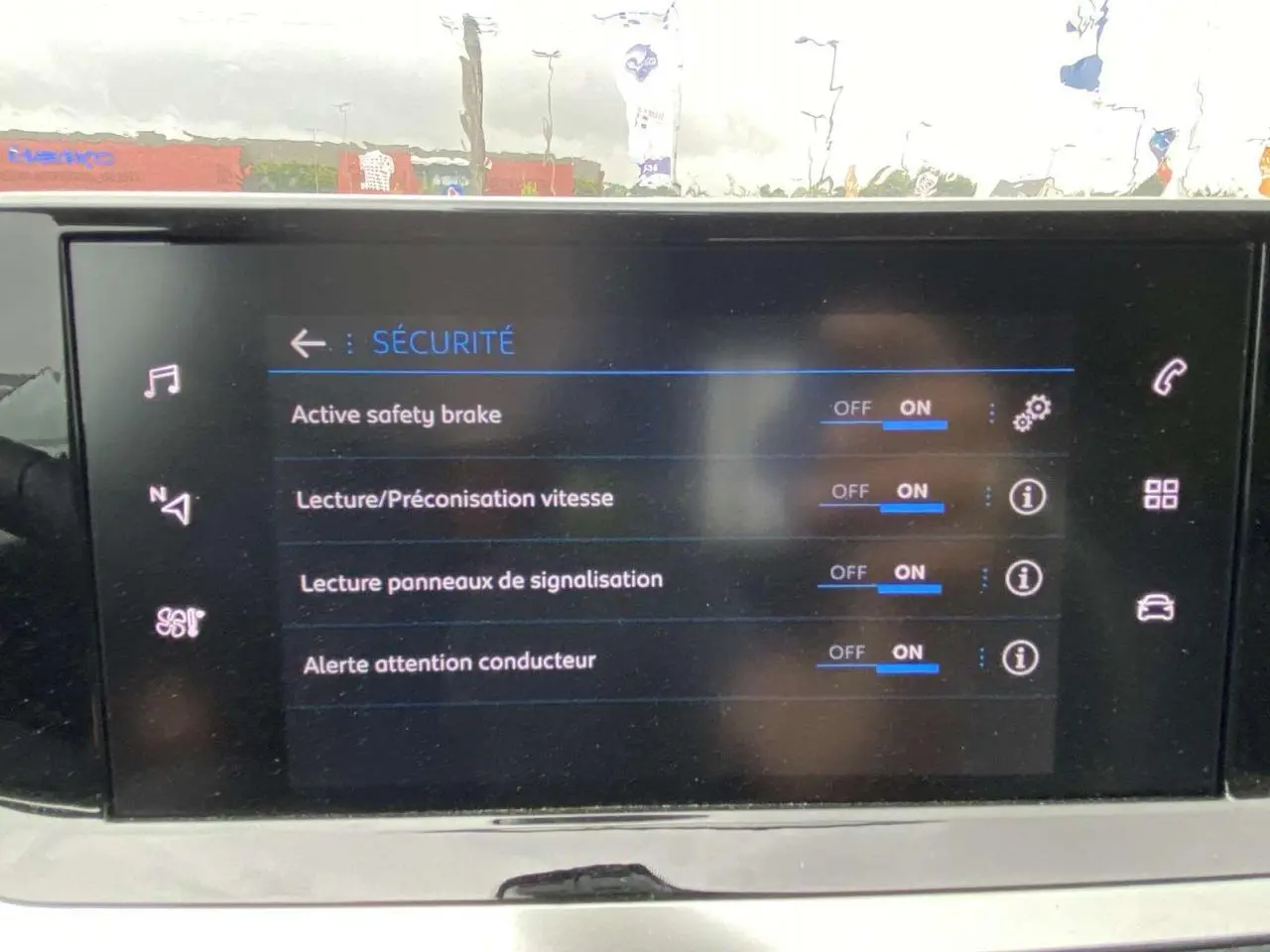 Écran tactile intérieur affichant les réglages de sécurité activés sur Peugeot 208 noire métallisée 2023.