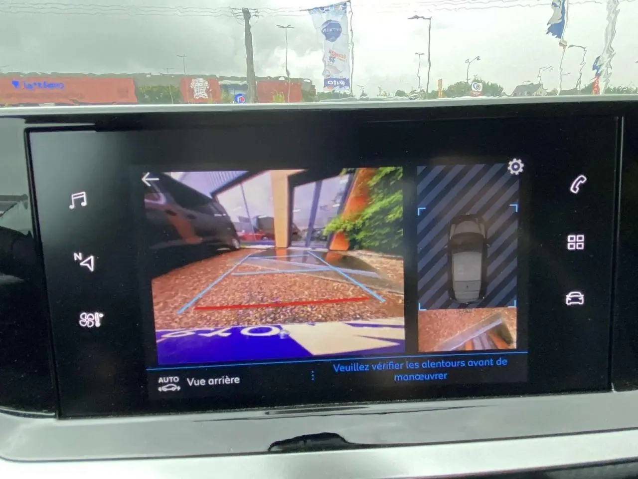Écran tactile du Peugeot 208 2023 montrant la caméra de recul avec aide graphique au stationnement arrière.