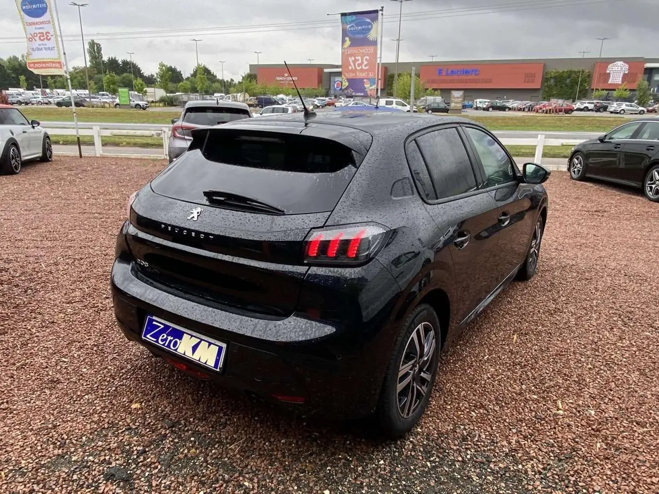 Vue 3/4 arrière droite d'une Peugeot 208 Allure 2023 noir métallisé avec feux arrière à LED et jantes alliage bi-tons.