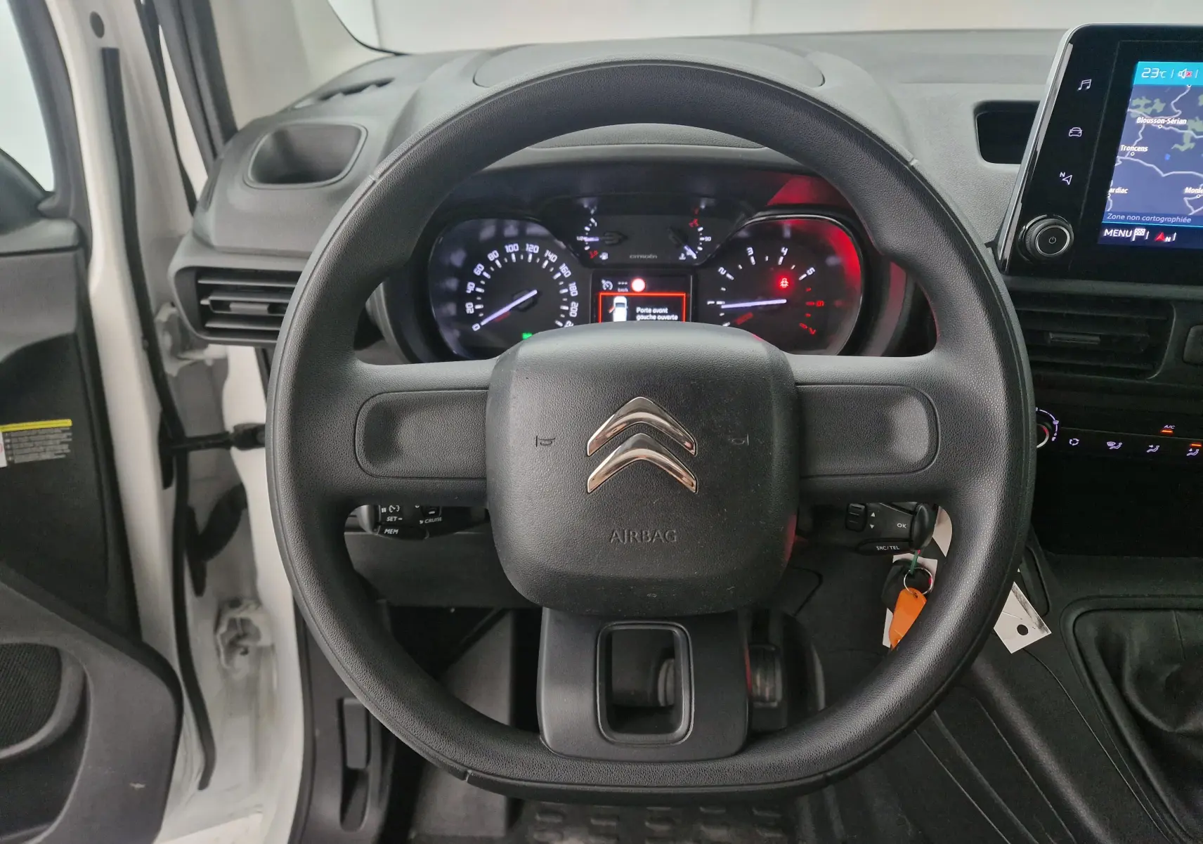 Vue intérieure centrée sur le volant noir du Citroën Berlingo blanc 2019 avec tableau de bord et écran tactile visible à droite.