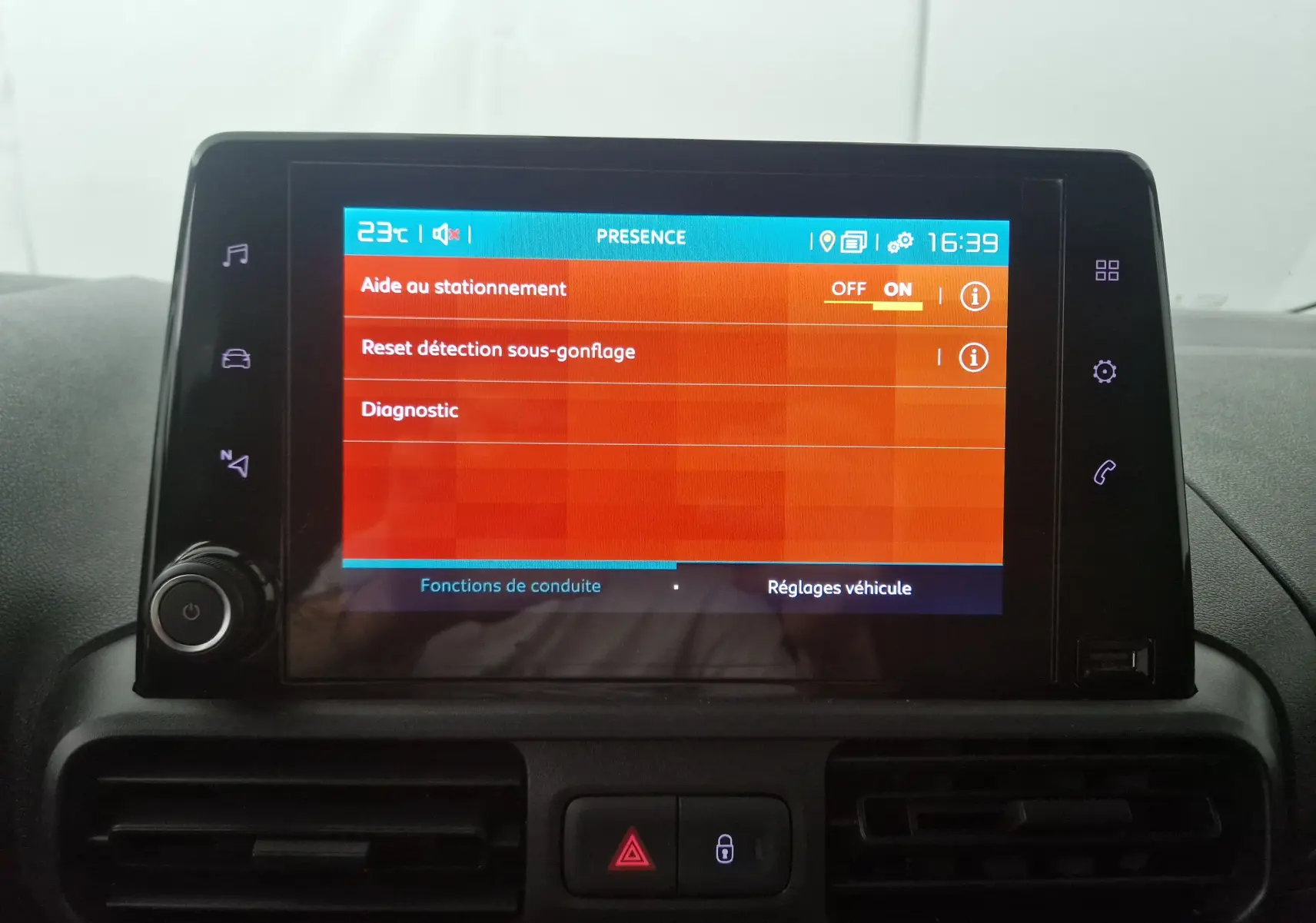 Écran tactile central du tableau de bord du Citroën Berlingo blanc, affichant les réglages d'aide au stationnement.