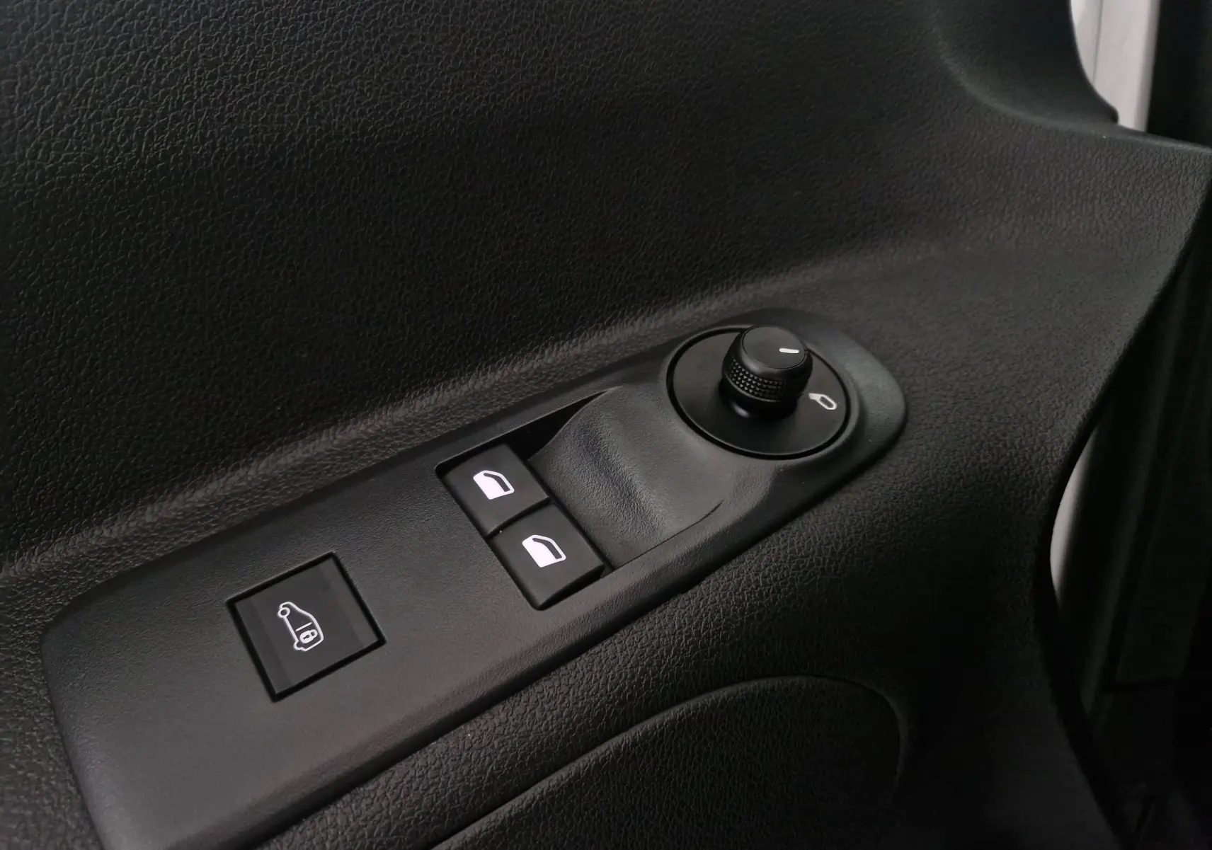 Vue rapprochée des commandes de lève-vitres et réglage des rétroviseurs côté conducteur du Citroën Berlingo blanc 2019.