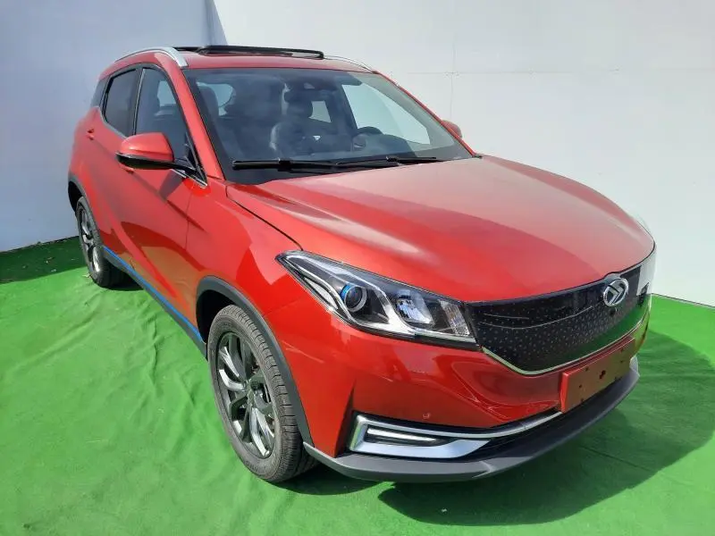 Vue 3/4 avant d'un SUV SERES 3 Luxury rouge carmin avec calandre noire et jantes aluminium sur fond vert.