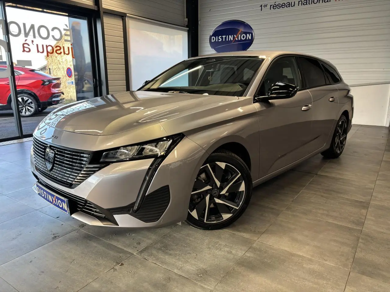 Peugeot 308 SW gris clair Metal Artense vue 3/4 avant droit, avec calandre noire et jantes alliage 17 pouces.