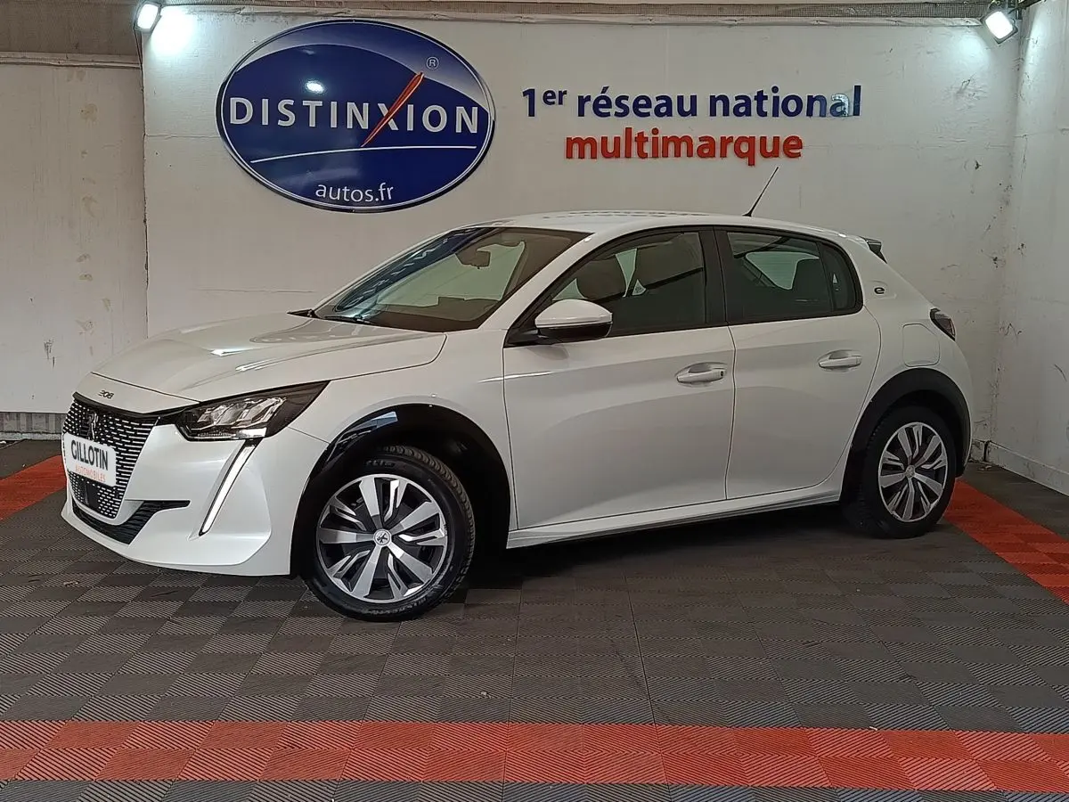 Peugeot 208 électrique blanche vue de profil côté gauche, avec jantes spécifiques et feux LED distinctifs.