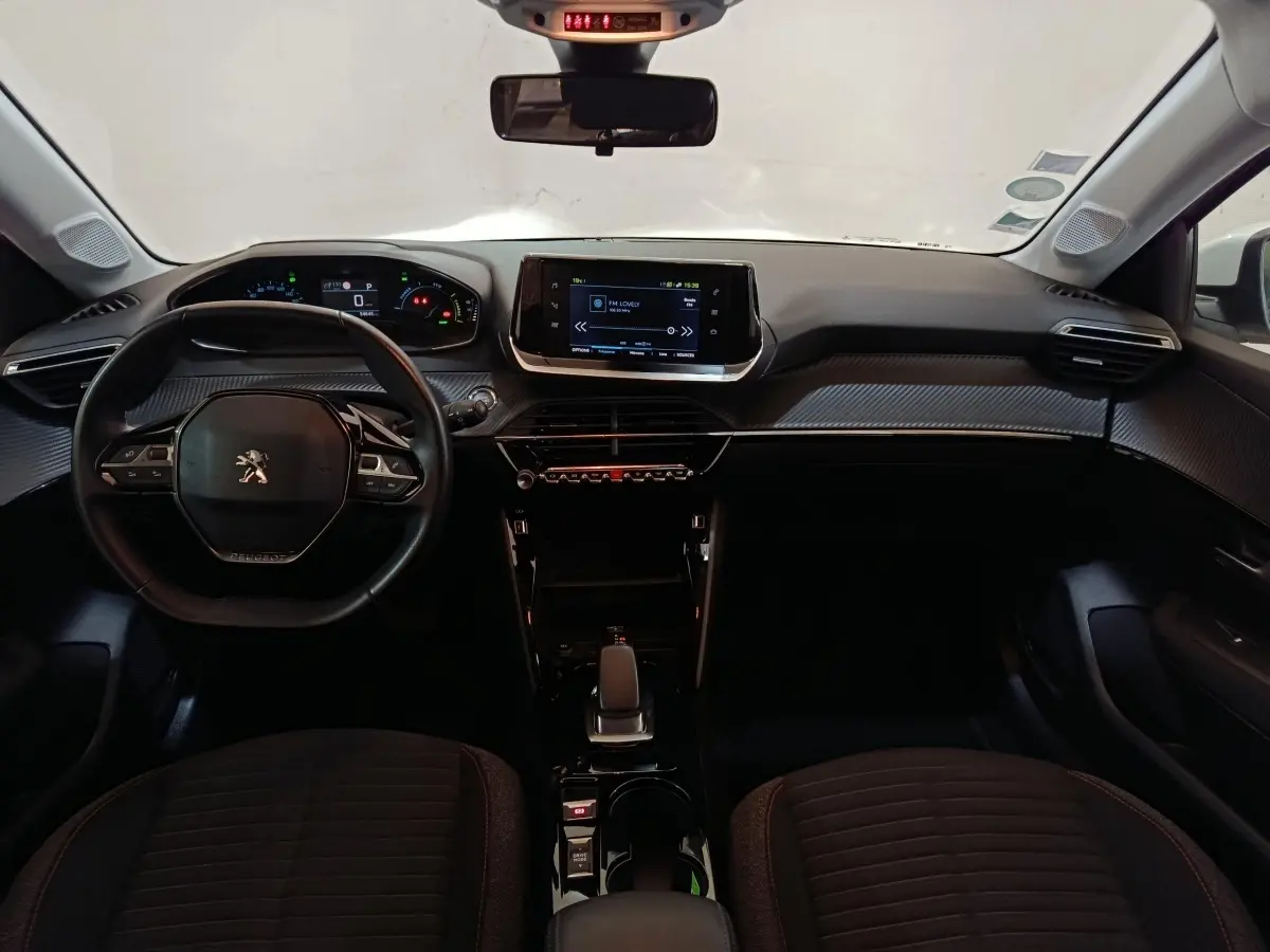 Vue intérieure avant de la Peugeot 208 électrique Active Business 2020, tableau de bord moderne avec écran tactile central.