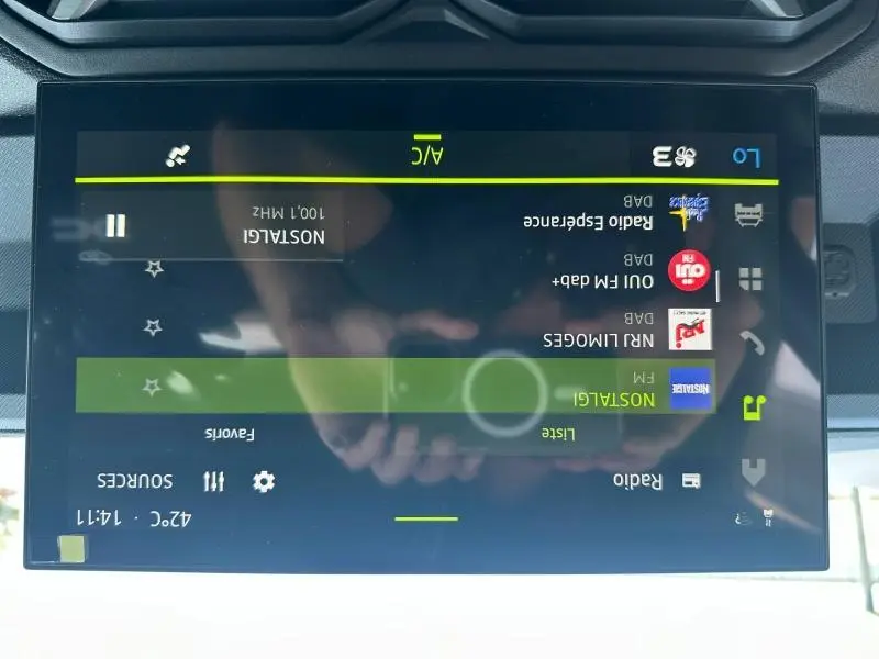 Écran tactile central du Dacia Duster 2025 affichant les stations radio avec interface claire et commandes visibles.